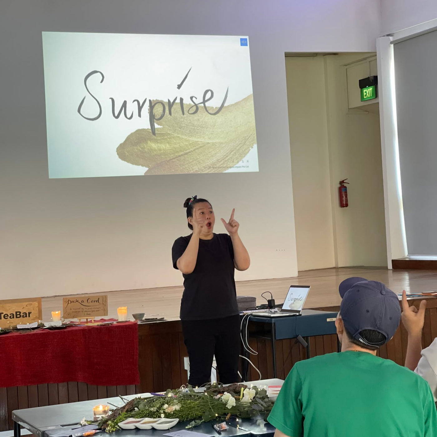 Person giving a presentation with a 'Surprise' slide projected on a screen.