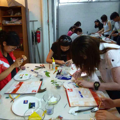 Group of people engaged in a craft or art activity at a table.
